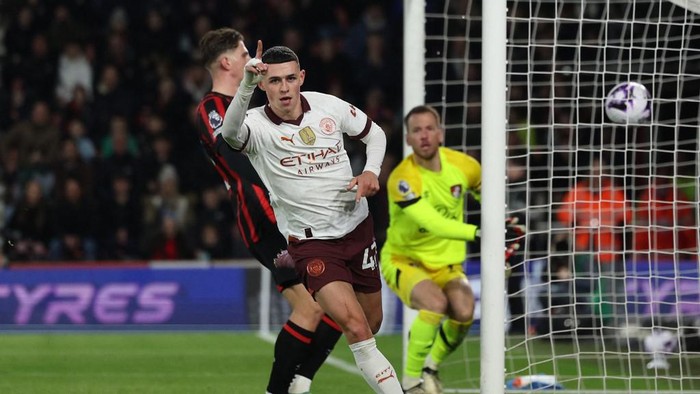Manchester Citys English midfielder #47 Phil Foden celebrates after scoring the opening goal of the English Premier League football match between Bournemouth and Manchester City at the Vitality Stadium in Bournemouth, southern England on February 24, 2024. (Photo by Adrian DENNIS / AFP) / RESTRICTED TO EDITORIAL USE. No use with unauthorized audio, video, data, fixture lists, club/league logos or live services. Online in-match use limited to 120 images. An additional 40 images may be used in extra time. No video emulation. Social media in-match use limited to 120 images. An additional 40 images may be used in extra time. No use in betting publications, games or single club/league/player publications. /