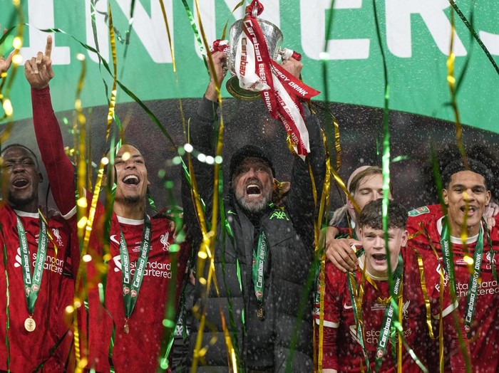 Liverpools manager Jurgen Klopp lifts the trophy next to Liverpools Virgil van Dijk as the team celebrates winning the English League Cup final soccer match between Chelsea and Liverpool at Wembley Stadium in London, Sunday, Feb. 25, 2024. (AP Photo/Alastair Grant)