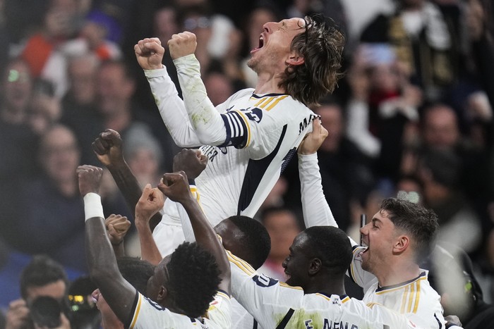 Real Madrids Luka Modric celebrates with his teammates after scoring his teams first goal during the Spanish La Liga soccer match between Real Madrid and Sevilla at the Santiago Bernabeu stadium in Madrid, Spain, Sunday, Feb. 25, 2024. (AP Photo/Manu Fernandez)