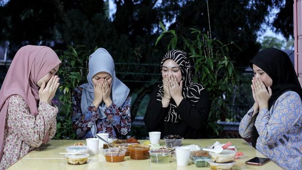 Muslim women are praying before dining.