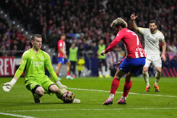Real Madrids goalkeeper Andriy Lunin saves a shot from Atletico Madrids Antoine Griezmann during their Copa del Rey round of 16 soccer match in Madrid, Spain, Thursday, Jan. 18, 2024. (AP Photo/Manu Fernandez)