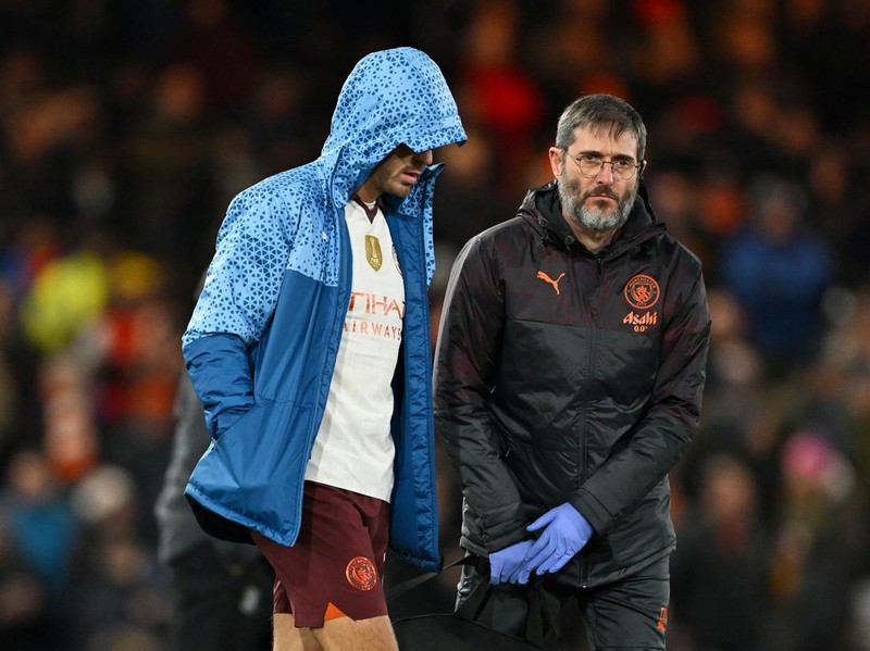 LUTON, ENGLAND - FEBRUARY 27: Jack Grealish of Manchester City looks dejected after picking up an injury as he makes his way to the dressing room at the end of the first half alongside a member of Manchester City's medical team during the Emirates FA Cup Fifth Round match between Luton Town and Manchester City at Kenilworth Road on February 27, 2024 in Luton, England. (Photo by Shaun Botterill/Getty Images)