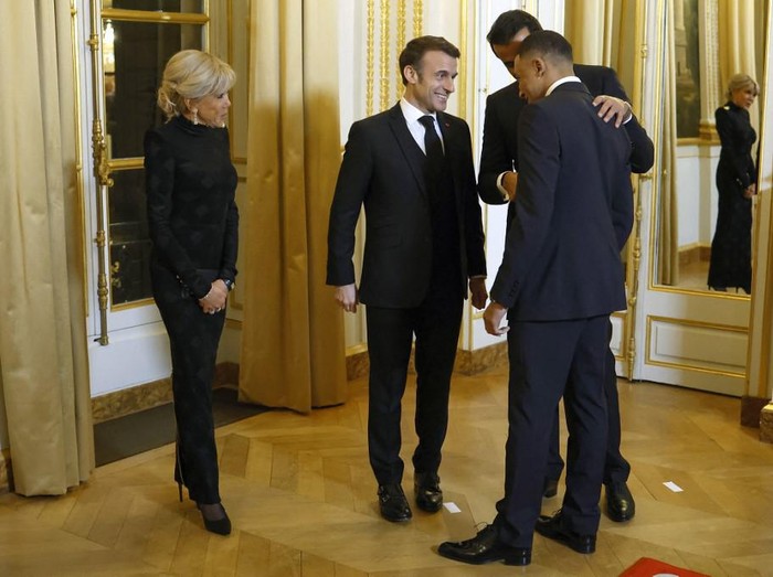 French President Emmanuel Macron (2L), French First Lady Brigitte Macron (L) and Qatari Emir Sheikh Tamim bin Hamad Al Thani greet Paris Saint Germain's French forward Kylian Mbappe during the entrance ceremony at the Elysee Palace before an official dinner on the sidelines of the Qatari Emir's state visit in Paris, February 27, 2024. (Photo by Yoan VALAT / POOL / AFP)