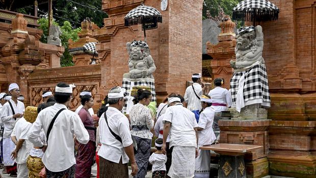 Balinese people gather for prayers at a temple to celebrate Galungan day in Denpasar, on Indonesia's resort island of Bali (28/2/2024). Galungan is a holiday celebrated by Balinese as a sign of victory of good against evil. (AFP/Sonny Tumbelaka)