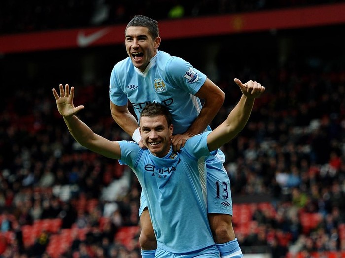 MANCHESTER, ENGLAND - OCTOBER 23:  Edin Dzeko of Manchester City celebrates scoring his team's sixth goal with team mate Aleksandar Kolarov  during the Barclays Premier League match between Manchester United and Manchester City at Old Trafford on October 23, 2011 in Manchester, England.  (Photo by Laurence Griffiths/Getty Images)