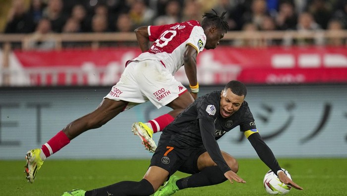 Monacos Wilfried Singo, top, challenges PSGs Kylian Mbappe during the French League One soccer match between Monaco and Paris Saint-Germain at the Stade Louis II in Monaco, Friday, March 1, 2024. (AP Photo/Daniel Cole)