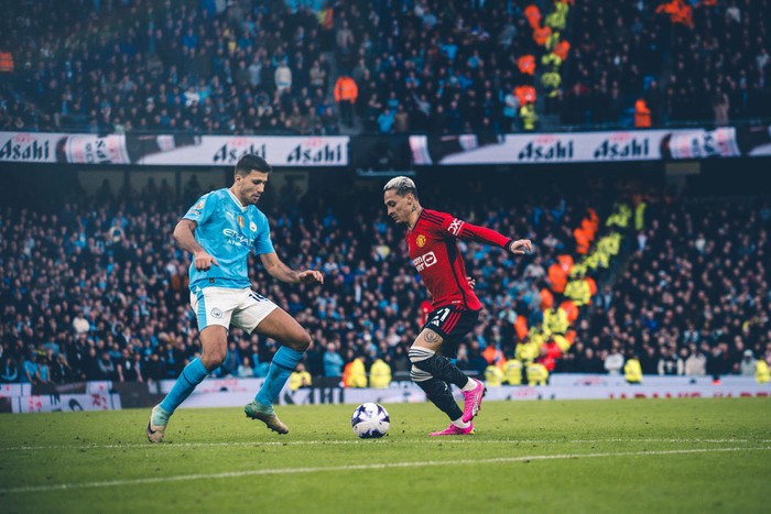 MANCHESTER, ENGLAND - MARCH 03: Antony of Manchester United in action with Rodri of Manchester City during the Premier League match between Manchester City and Manchester United at Etihad Stadium on March 03, 2024 in Manchester, England. (Photo by Ash Donelon/Manchester United via Getty Images)