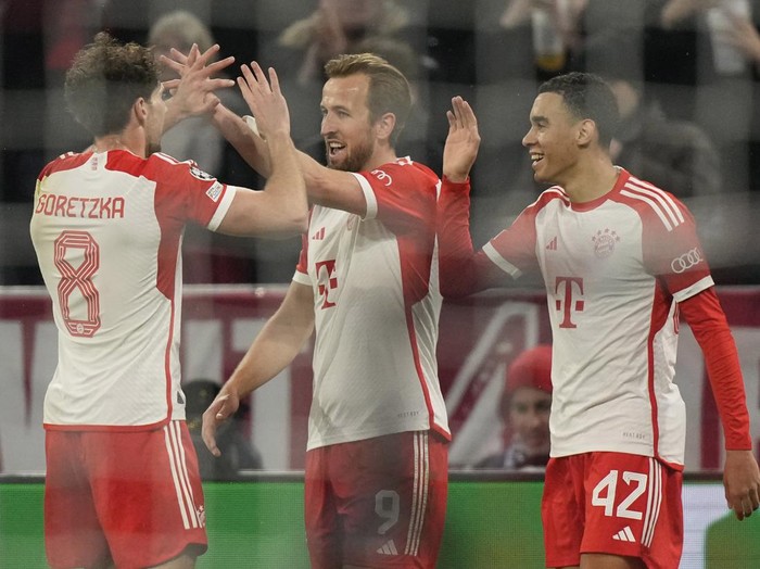 Bayern's Harry Kane, center, celebrates with his teammates after scoring his side's third goal during the Champions League round of 16 second leg soccer match between FC Bayern Munich and Lazio at the Allianz Arena stadium in Munich, Germany, Tuesday, March 5, 2024. (AP Photo/Matthias Schrader)