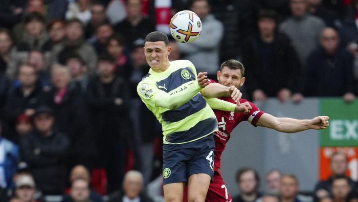 Manchester Citys Phil Foden, left, duels for the ball with Liverpools James Milner during the English Premier League soccer match between Liverpool and Manchester City at Anfield stadium in Liverpool, Sunday, Oct. 16, 2022. (AP Photo/Jon Super)
