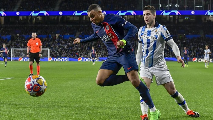 PSGs Kylian Mbappe, center, duels for the ball with Real Sociedads Igor Zubeldia during the Champions League round of 16 second leg soccer match between Real Sociedad and Paris Saint-Germain, at the Reala Arena stadium in San Sebastian, Spain, Tuesday, March 5, 2024. (AP Photo/Alvaro Barrientos)