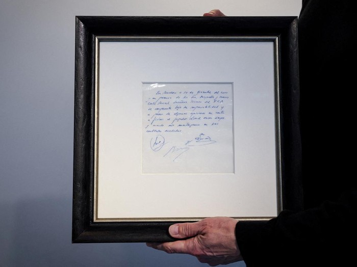 A guest looks at a napkin, written on by Barcelona's Sporting Director at that time Carles Rexach on December 14, 2000, promising a contract to secure 13-year-old Lionel Messi for FC Barcelona, on display at Bonhams Auctions in New York City, U.S., March 6, 2024.  REUTERS/Brendan McDermid