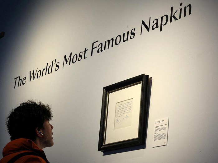 A guest looks at a napkin, written on by Barcelona's Sporting Director at that time Carles Rexach on December 14, 2000, promising a contract to secure 13-year-old Lionel Messi for FC Barcelona, on display at Bonhams Auctions in New York City, U.S., March 6, 2024.  REUTERS/Brendan McDermid