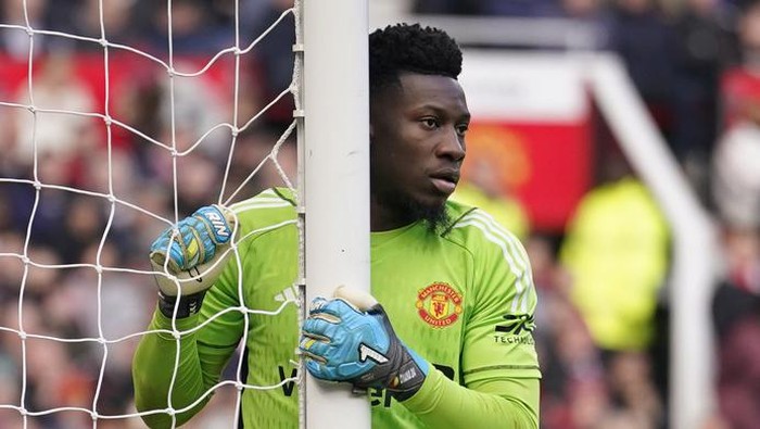 Manchester Uniteds goalkeeper Andre Onana holds the goalpost after making a save during an English Premier League soccer match between Manchester United and Everton at the Old Trafford stadium in Manchester, England, Saturday, March 9, 2024. (AP Photo/Dave Thompson)