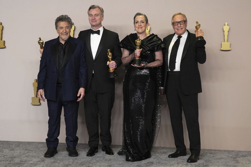 Christopher Nolan poses in the press room with the awards for best director and best picture for 