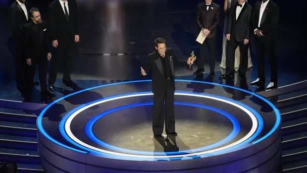 Robert Downey Jr. poses in the press room with the award for best performance by an actor in a supporting role for 