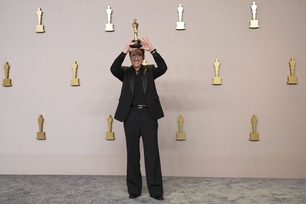 Robert Downey Jr. poses in the press room with the award for best performance by an actor in a supporting role for 