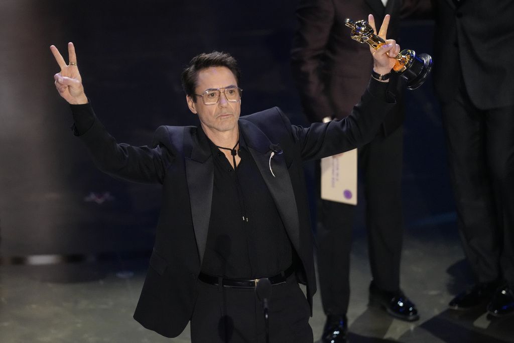 Robert Downey Jr. poses in the press room with the award for best performance by an actor in a supporting role for 