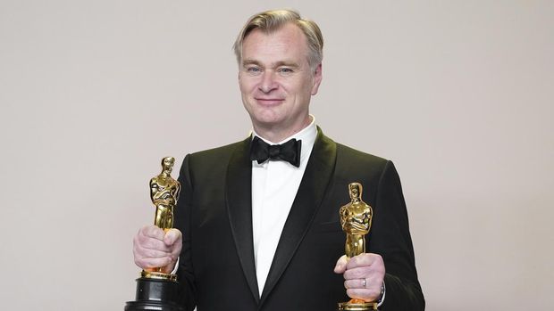 Christopher Nolan poses in the press room with the awards for best director and best picture for 