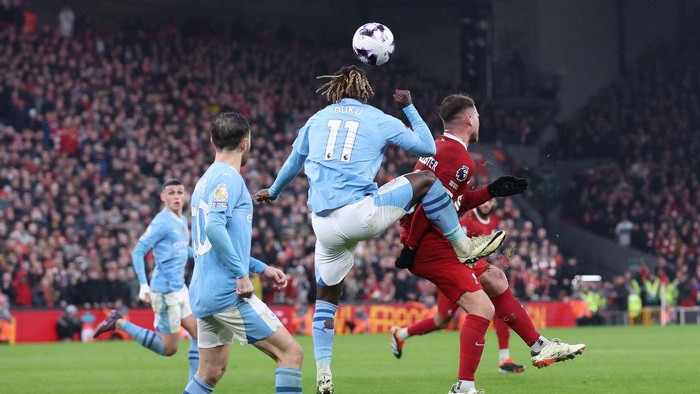 LIVERPOOL, ENGLAND - MARCH 10: Jeremy Doku of Manchester City kicks Alexis Mac Allister of Liverpool during the Premier League match between Liverpool FC and Manchester City at Anfield on March 10, 2024 in Liverpool, England. (Photo by Alex Livesey - Danehouse/Getty Images)