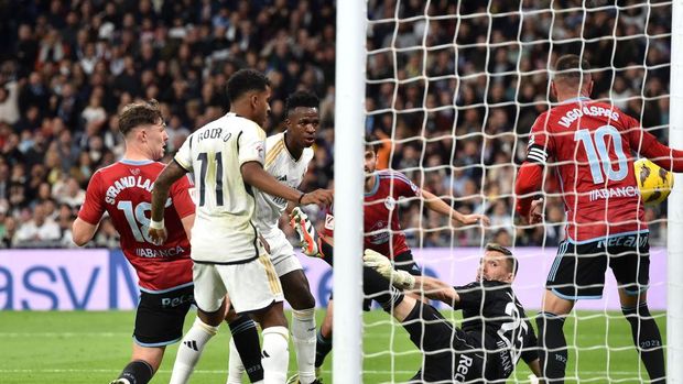 MADRID, SPAIN - MARCH 10: Vinicius Junior of Real Madrid scores his team's first goal past Vicente Guaita of Celta Vigo during the LaLiga EA Sports match between Real Madrid CF and Celta Vigo at Estadio Santiago Bernabeu on March 10, 2024 in Madrid, Spain. (Photo by Denis Doyle/Getty Images)