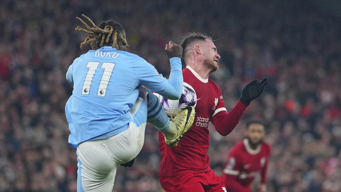 Alexis Mac Allister CAPTION CORRECTS PLAYER ID ON THE RIGHT Manchester City's Jeremy Doku, foreground, and Liverpool's Alexis Mac Allister fight for the ball during the English Premier League soccer match between Liverpool and Manchester City, at Anfield stadium in Liverpool, England, Sunday, March 10, 2024. (AP Photo/Jon Super)