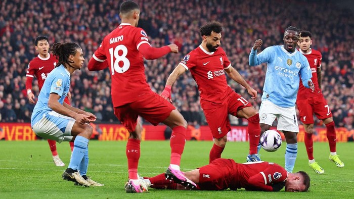 LIVERPOOL, ENGLAND - MARCH 10: Alexis Mac Allister of Liverpool reacts after a tackle by Jérémy Doku of Manchester City  during the Premier League match between Liverpool FC and Manchester City at Anfield on March 10, 2024 in Liverpool, England.(Photo by Robbie Jay Barratt - AMA/Getty Images)