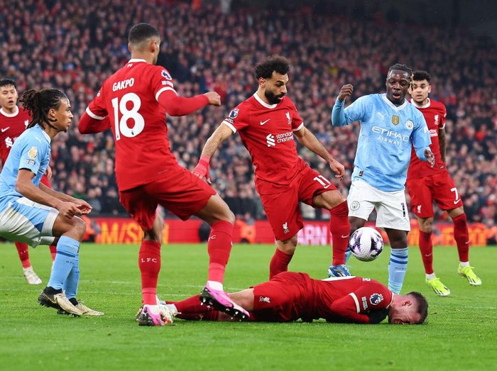 LIVERPOOL, ENGLAND - MARCH 10: Alexis Mac Allister of Liverpool reacts after a tackle by Jérémy Doku of Manchester City  during the Premier League match between Liverpool FC and Manchester City at Anfield on March 10, 2024 in Liverpool, England.(Photo by Robbie Jay Barratt - AMA/Getty Images)