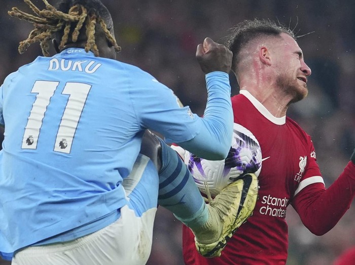 CAPTION CORRECTS PLAYER ID ON THE RIGHT Manchester City's Jeremy Doku, foreground, and Liverpool's Alexis Mac Allister fight for the ball during the English Premier League soccer match between Liverpool and Manchester City, at Anfield stadium in Liverpool, England, Sunday, March 10, 2024. (AP Photo/Jon Super)