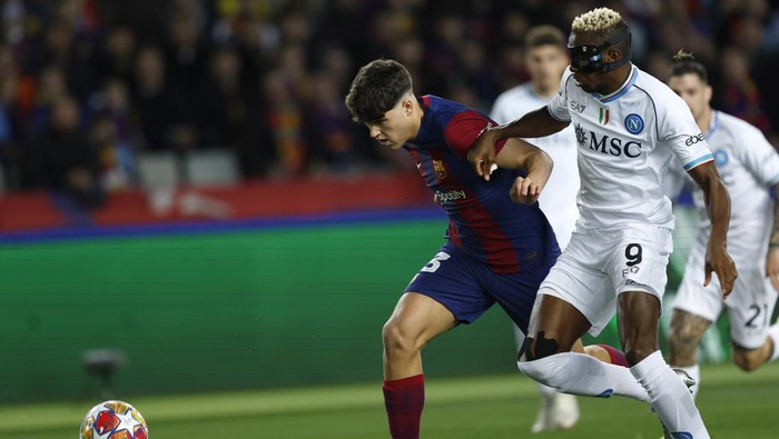 Napolis Victor Osimhen, right, challenges Barcelonas Pau Cubarsi during the Champions League, round of 16, second leg soccer match between FC Barcelona and SSC Napoli at the Olympic Stadium in Barcelona, Spain, Tuesday, March 12, 2024. (AP Photo/Joan Monfort)