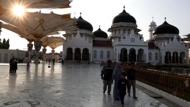 Warga berjalan di halaman Masjid Raya Baiturrahman saat menunggu waktu untuk berbuka puasa (ngabuburit) di Banda Aceh, Aceh, Selasa (12/3/2024). Masjid Raya yang dibangun tahun 1612 pada masa pemerintahan Sultan Iskandar Muda itu menjadi pilihan warga untuk ngabuburit. ANTARA FOTO /Irwansyah Putra