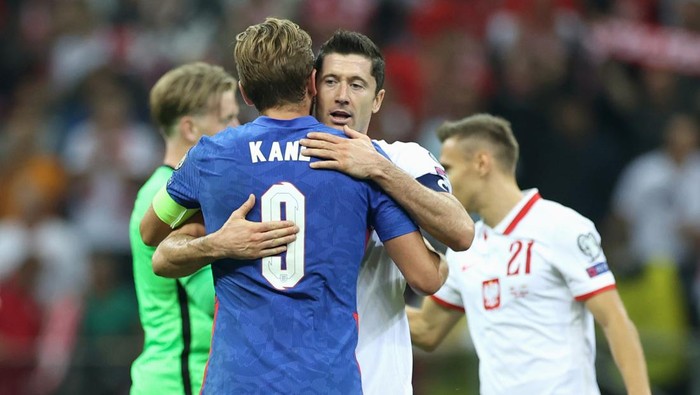 WARSAW, POLAND - SEPTEMBER 08: Harry Kane of England and Robert Lewandowski of Poland embrace following the 2022 FIFA World Cup Qualifier match between Poland and England at Stadion Narodowy on September 08, 2021 in Warsaw, Poland. (Photo by Eddie Keogh - The FA/The FA via Getty Images)