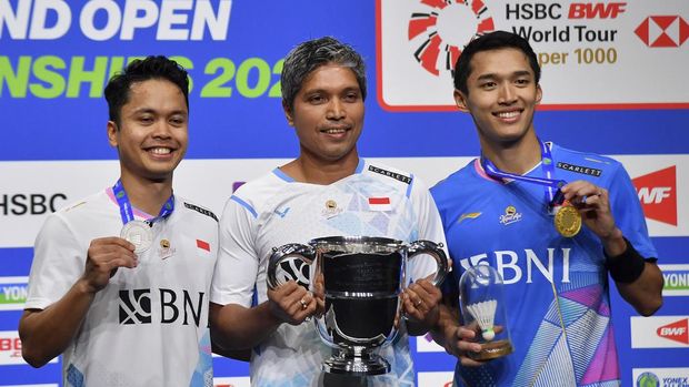 Indonesia's Anthony Sinisuka Ginting, left, and Indonesia's Jonatan Christie, right pose with coach Irwansyah, centre, after the men's singles final match of the All England Open Badminton Championships at the Utilita Arena in Birmingham, England, Sunday, March 17, 2024. (AP Photo/Rui Vieira)