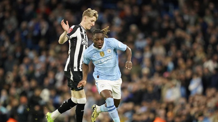Newcastles Anthony Gordon, left, challenges for the ball with Manchester Citys Jeremy Doku during the FA Cup quarterfinal soccer match between Manchester City and Newcastle at the Etihad Stadium in Manchester, England, Saturday, March 16, 2024. (AP Photo/Dave Thompson, Pool)