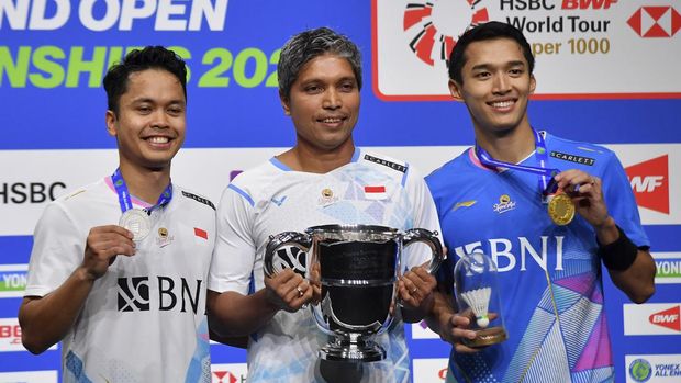 Indonesia's Anthony Sinisuka Ginting, left, and Indonesia's Jonatan Christie, right pose with coach Irwansyah, centre, after the men's singles final match of the All England Open Badminton Championships at the Utilita Arena in Birmingham, England, Sunday, March 17, 2024. (AP Photo/Rui Vieira)