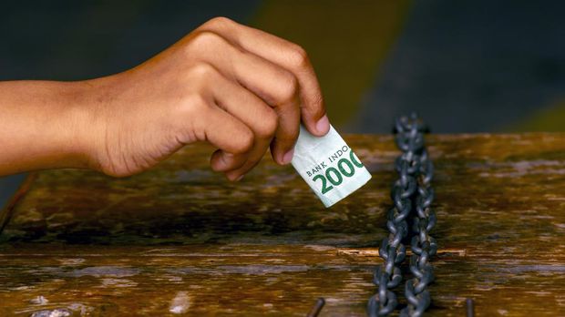 Infaq, an asian child hand put money in a charity box for donation