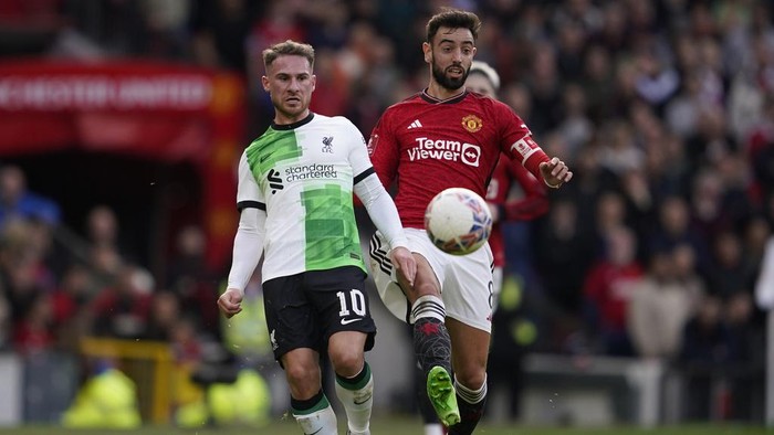 Liverpools Alexis Mac Allister, left, is challenged by Manchester Uniteds Bruno Fernandes during the FA Cup quarterfinal soccer match between Manchester United and Liverpool at the Old Trafford stadium in Manchester, England, Sunday, March 17, 2024. (AP Photo/Dave Thompson)