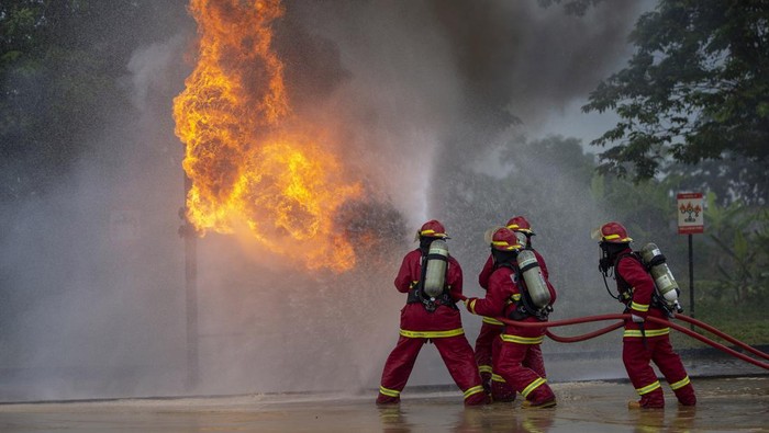 Peserta berupaya memadamkan api yang mengkremasi saluran pipa dikala kontes âfire combatâ di Pertamina EP Jatibarang Field, Indramayu, Jawa Barat.