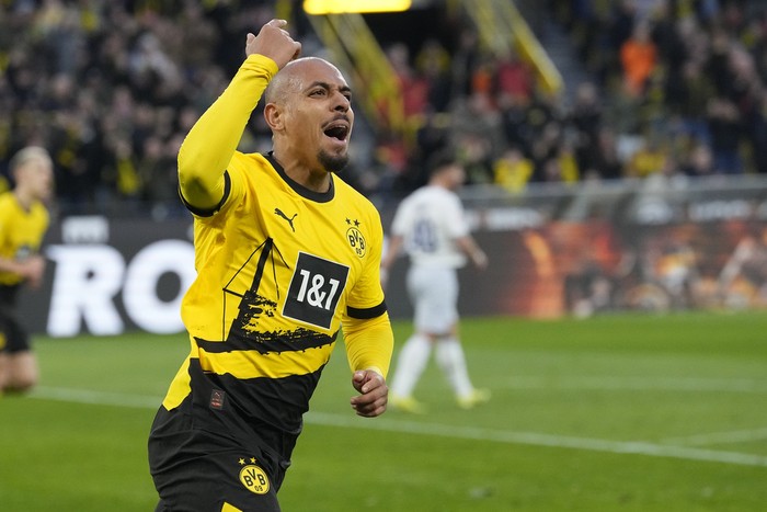 Dortmunds Donyell Malen celebrates after scoring his sides opening goal during the German Bundesliga soccer match between Borussia Dortmund and TSG Hoffenheim in Dortmund, Germany, Sunday, Feb. 25, 2024. (AP Photo/Martin Meissner)