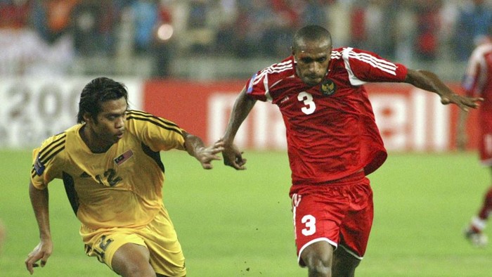 Malaysias Muhammad Shukor Adnan (L) and Indonesias Ortizan Salossa (R) chase the ball during the second leg of their semifinal match in the Asian Tiger Cup football tournament in Kuala Lumpur, 03 January 2005. AFP PHOTO/Tengku Bahar (Photo by TENGKU BAHAR / AFP)