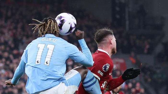LIVERPOOL, ENGLAND - MARCH 10: Jeremy Doku of Manchester City kicks Alexis Mac Allister of Liverpool during the Premier League match between Liverpool FC and Manchester City at Anfield on March 10, 2024 in Liverpool, England. (Photo by Alex Livesey - Danehouse/Getty Images)