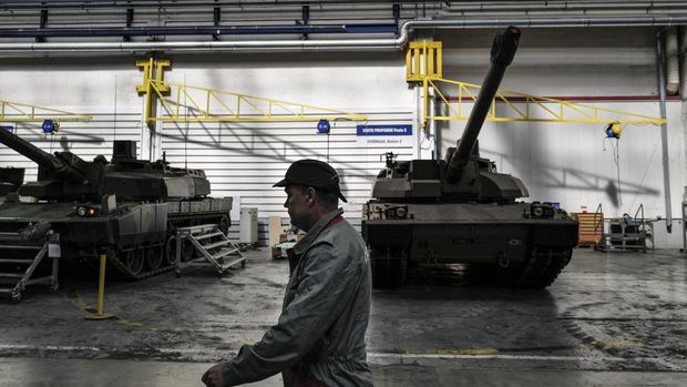 An employee walks near a Leclerc tank at the NEXTER factory in Roanne, central France. (Photo by OLIVIER CHASSIGNOLE / AFP)