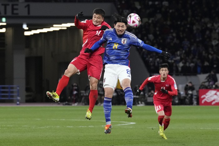 Japans Takumi Minamino, right, competes for the ball with North Koreas Choe Ok Chol during the FIFA World Cup 2026 and AFC Asian Cup 2027 preliminary joint qualification round 2 match between Japan and North Korea at the National Stadium Thursday, March 21, 2024, in Tokyo. (AP Photo/Eugene Hoshiko)