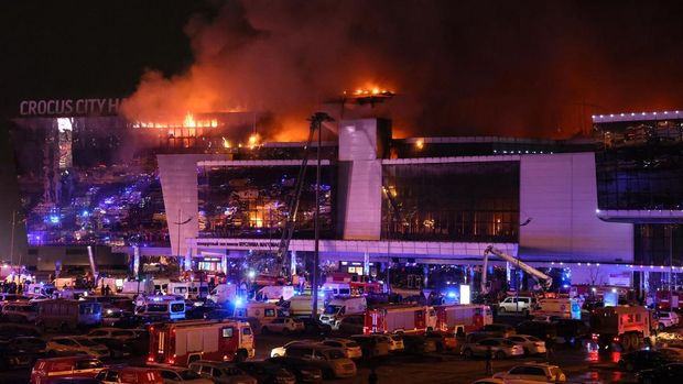 Emergency services vehicles are seen outside the burning Crocus City Hall concert hall following the shooting incident in Krasnogorsk, outside Moscow, on March 22, 2024. Gunmen opened fire at a concert hall in a Moscow suburb on March 22, 2024 leaving dead and wounded before a major fire spread through the building, Moscow's mayor and Russian news agencies reported. (Photo by STRINGER / AFP)