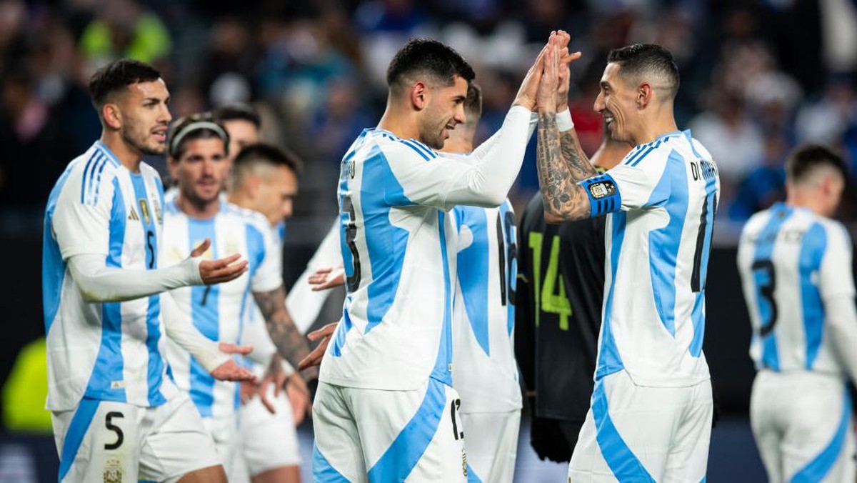 Angel Di Maria (kanan) menghampiri Cristian Romero (tengah) yang mencetak gol pertama Argentina. Foto: Getty Images/Ira L. Black