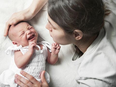 Newborn crying, sleep of children. Tired Mother with Upset Baby Suffering with Post Natal Depression.