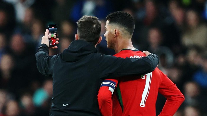 Soccer Football - International Friendly - Slovenia v Portugal - Stozice Stadium, Ljubjana, Slovenia - March 26, 2024 A pitch invader takes a selfie with Portugals Cristiano Ronaldo REUTERS/Borut Zivulovic