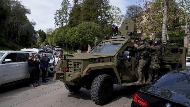 Law enforcement rides a vehicle near a property belonging to Sean 