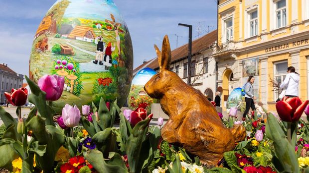 A man walks next to structures depicting Easter eggs painted in the traditional naive art style in Koprivnica, Croatia, March 27, 2024. REUTERS/Antonio Bronic
