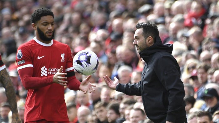 Brightons head coach Roberto De Zerbi, right, gives the ball to Liverpools Joe Gomez during the English Premier League soccer match between Liverpool and Brighton and Hove at Anfield Stadium in Liverpool, England, Sunday, March 31, 2024. (AP Photo/Rui Vieira)