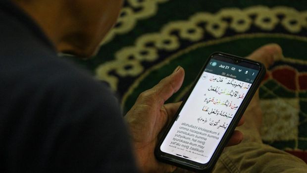 Umat Islam membaca Al Quran digital saat beriktikaf di Masjid Nasional Al Akbar Surabaya, Jawa Timur, Senin (1/4/2024) dini hari. Iktikaf yang dilakukan 10 hari menjelang berakhirnya bulan Ramadhan itu untuk meraih malam kemuliaan (Lailatul Qadar) dengan membaca Al Quran, Salat Tahajud (malam) dan berdzikir. ANTARA FOTO/Didik Suhartono